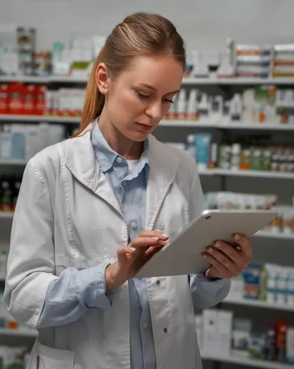 Farmacéutica usando una tablet en su farmacia