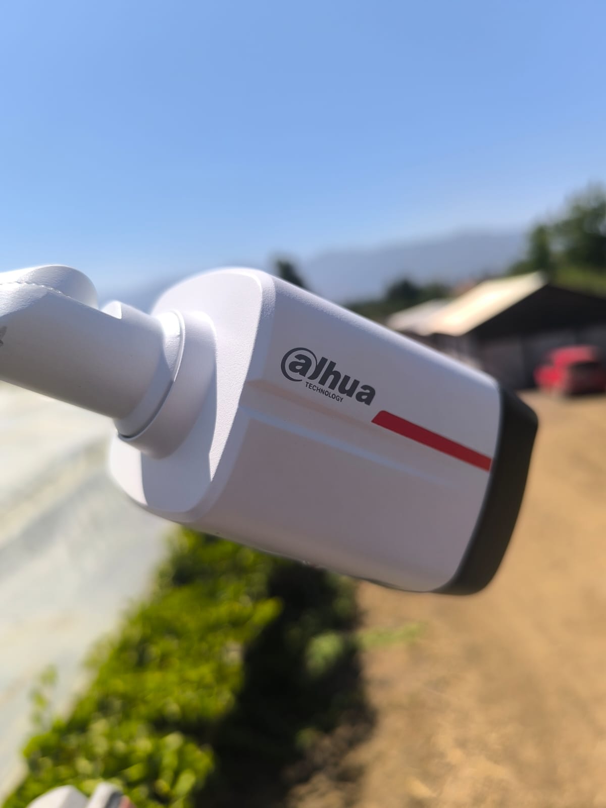 Cámara instalada en un predio agrícola, con camino y galpón al fondo