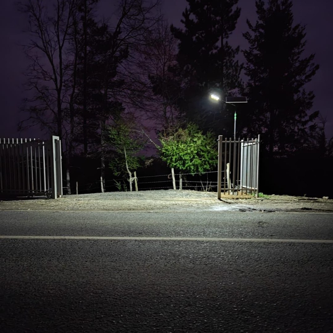 Acceso con portón iluminado de noche con luminaria solar