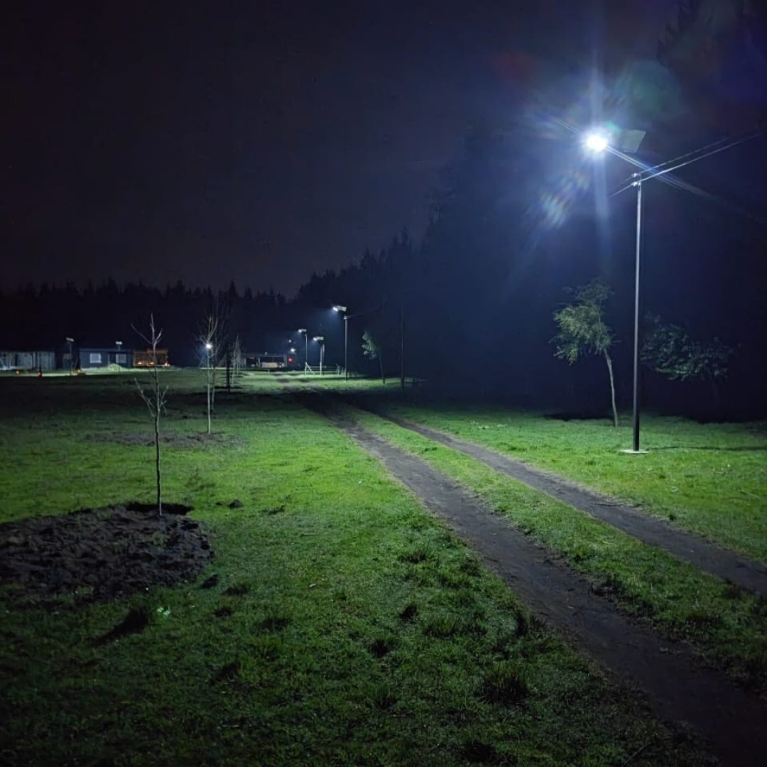 Camino de tierra iluminado de noche por una luminaria solar