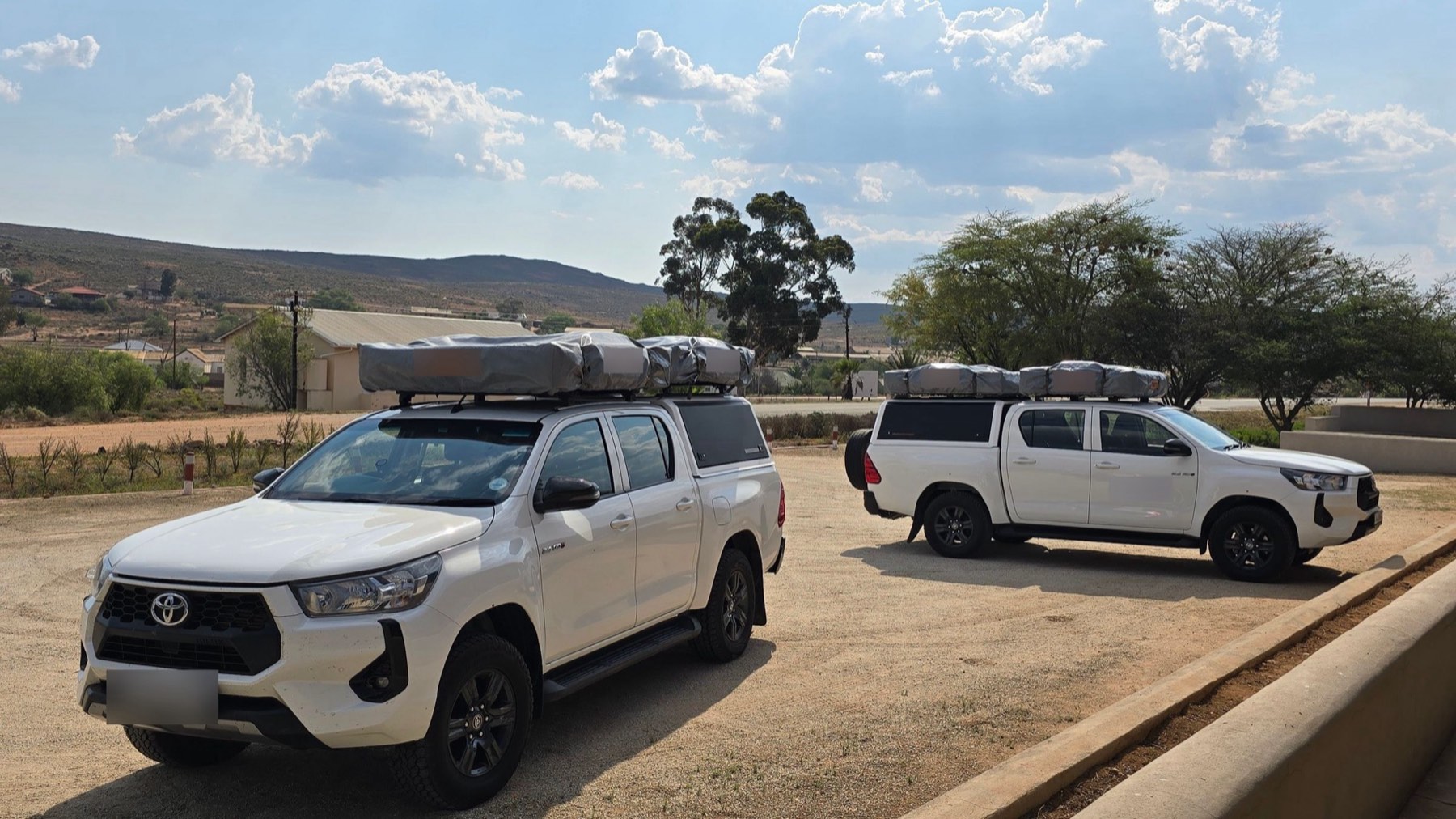 Camionetas blancas en un camino de tierra