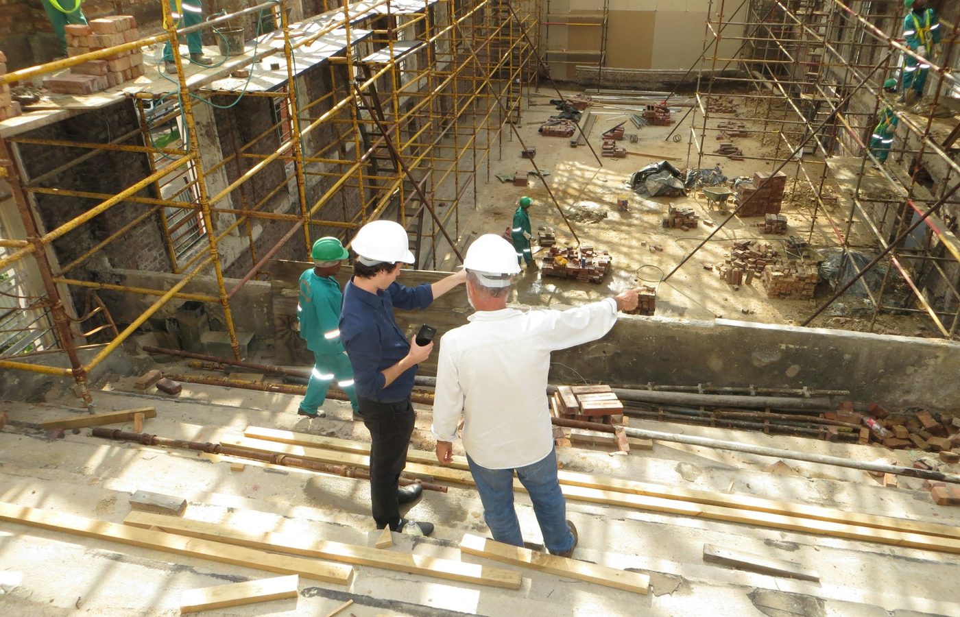 Dos profesionales con casco supervisan una obra en construcción